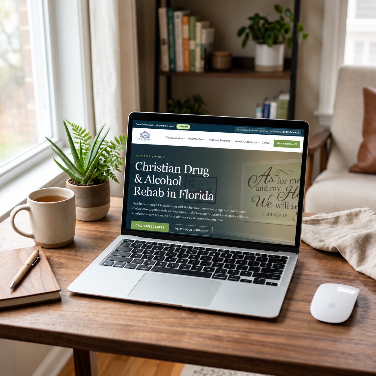 JC Recovery Center homepage displayed in a laptop mockup on a wooden desk